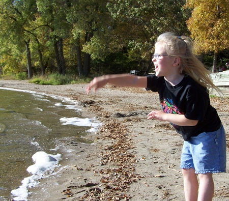 Anna throwing rocks in the lake