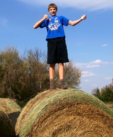 Caleb on top of the roll of hay