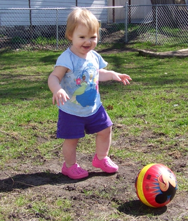 Ella kicking a ball
