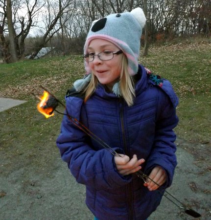 Anna with a burning marshmallow