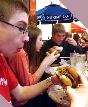 Caleb digging into a burger