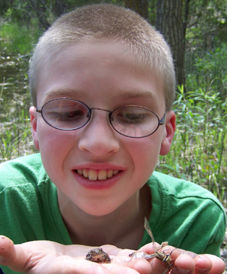 Caleb with a dragonfly and toad