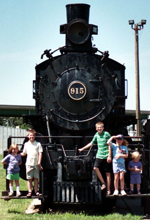 the kids posing in front of a train