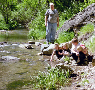 the kids and Grandpa stream-side