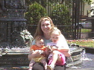 Shannon holding Marosa and Annora at the fountain